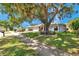Beautiful single-Gathering home with an expansive front lawn and mature tree, offering shade and curb appeal at 3957 Tarpon Pointe Cir, Palm Harbor, FL 34684