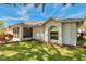 Charming home with a well-manicured lawn, arched window, and a cozy screened-in porch on a sunny day at 3957 Tarpon Pointe Cir, Palm Harbor, FL 34684
