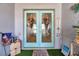 Elegant double front doors with glass panels and decorative wreaths, adding curb appeal and charm at 3957 Tarpon Pointe Cir, Palm Harbor, FL 34684