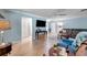 Bright living room with light wood floors, blue walls, ceiling fan, and a comfortable seating area at 3957 Tarpon Pointe Cir, Palm Harbor, FL 34684