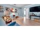 Cozy living room featuring light wood floors, blue walls, personal photos, and comfortable seating at 3957 Tarpon Pointe Cir, Palm Harbor, FL 34684
