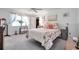 This main bedroom features a ceiling fan, a bright window with sheer curtains and a decorative floral theme at 3957 Tarpon Pointe Cir, Palm Harbor, FL 34684