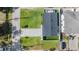 An aerial shot of the home and yard features a manicured lawn, mature landscaping, and a concrete driveway at 401 N Manhattan Ave, Tampa, FL 33609