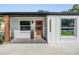 Close up on a modern orange front door of a stylish, renovated home with beautiful landscaping at 401 N Manhattan Ave, Tampa, FL 33609
