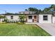 Charming single-story home featuring an orange front door, manicured lawn, and modern accents at 401 N Manhattan Ave, Tampa, FL 33609