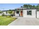 Charming single-story home with a neatly landscaped front yard, modern windows, and a stylish door at 401 N Manhattan Ave, Tampa, FL 33609