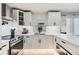 Well-lit kitchen featuring stainless steel appliances, white cabinetry, and stone countertops at 401 N Manhattan Ave, Tampa, FL 33609