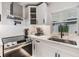 Bright kitchen featuring stainless steel appliances, white cabinetry, and stone countertops at 401 N Manhattan Ave, Tampa, FL 33609