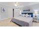 Bright bedroom with gray walls, a ceiling fan, and a painting of sailboats, with an open closet at 4103 Gulf Blvd # 106, St Pete Beach, FL 33706