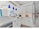 Modern kitchen with white cabinets, stainless steel appliances, and charming breakfast bar at 4103 Gulf Blvd # 106, St Pete Beach, FL 33706