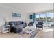 The stylish living room is furnished with a comfortable sofa, chairs, and a water view at 4103 Gulf Blvd # 106, St Pete Beach, FL 33706