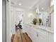Elegant bathroom features a double sink vanity with white cabinets and wood flooring, with a workout room in view at 4204 Saltwater Blvd, Tampa, FL 33615