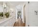 Bright bathroom boasts a double sink vanity, hardwood floors, and tiled walk-in shower with glass doors at 4204 Saltwater Blvd, Tampa, FL 33615