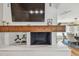 Living room fireplace boasts stone hearth, rustic wood mantel, with wall-mounted tv and artistic decor at 4204 Saltwater Blvd, Tampa, FL 33615