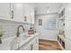 Well-lit laundry room features white cabinets, marble countertops, tiled backsplash, and stainless faucet at 4204 Saltwater Blvd, Tampa, FL 33615