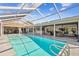 Inviting screened-in pool area with a clear blue swimming pool, outdoor dining and a comfortable seating area at 4204 Saltwater Blvd, Tampa, FL 33615