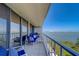 Inviting condo balcony showcasing serene water views and comfortable seating with nautical decor under a clear blue sky at 500 N Osceola Ave # 609, Clearwater, FL 33755