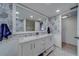 Bright bathroom with marble floors, double sink vanity, decorative wallpaper, and a walk-in shower at 500 N Osceola Ave # 609, Clearwater, FL 33755