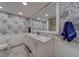 Bright bathroom with marble floors, double sink vanity, decorative wallpaper, and a walk-in shower at 500 N Osceola Ave # 609, Clearwater, FL 33755