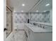 Bright bathroom with marble floors, double sink vanity, decorative wallpaper, and a walk-in shower at 500 N Osceola Ave # 609, Clearwater, FL 33755