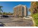 View of condo building showing ample parking, lush vegetation and waterfront proximity on a clear day at 500 N Osceola Ave # 609, Clearwater, FL 33755