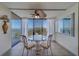 Dining area with a glass table set, ceiling fan, and sliding glass doors with views of the water at 500 N Osceola Ave # 609, Clearwater, FL 33755