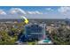 Modern high-rise condo building featuring balconies, a parking area, and a refreshing swimming pool surrounded by lush greenery at 500 N Osceola Ave # 609, Clearwater, FL 33755