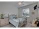 Cozy bedroom with a metal-frame bed, wood flooring, and large window at 5104 2Nd E Ave, Palmetto, FL 34221