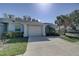 Inviting single-story home with a spacious driveway, attached garage, and lush tropical landscaping at 5104 2Nd E Ave, Palmetto, FL 34221