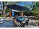 Cozy backyard featuring a paver patio, dining table under an umbrella, and a shed at 525 Lexington St, Dunedin, FL 34698