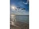Beautiful beach scene showcasing the shoreline meeting the ocean under a bright, partly cloudy sky at 525 Lexington St, Dunedin, FL 34698