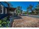 Brick driveway leading to a blue home with wood porch and landscaping at 525 Lexington St, Dunedin, FL 34698