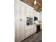Custom kitchen features white cabinets, sleek black appliances, and built-in coffee bar for a modern and functional design at 525 Lexington St, Dunedin, FL 34698