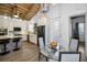 Open kitchen with white cabinets, black appliances and dining area with unique light fixture and wood-beamed ceiling at 525 Lexington St, Dunedin, FL 34698