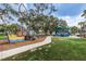 Playground with colorful play structures, walking path, and green grass providing recreational opportunities for families at 525 Lexington St, Dunedin, FL 34698