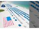 Expansive beach view with rows of blue canopies and an American flag pattern in the sand at 5500 Gulf Blvd # 4246, St Pete Beach, FL 33706