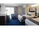 A charming bedroom with two beds, patterned chairs, and abundant natural light at 5500 Gulf Blvd # 4246, St Pete Beach, FL 33706