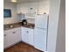 A compact kitchen featuring a refrigerator, microwave, and a small stovetop at 5500 Gulf Blvd # 4246, St Pete Beach, FL 33706