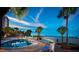 Stunning pool and beach view featuring multiple lounge chairs and tall palm trees at 5500 Gulf Blvd # 4246, St Pete Beach, FL 33706