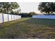 Expansive backyard features a well-manicured lawn, white perimeter fence, and mature trees for privacy at 601 Gay Rd, Seffner, FL 33584