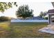 Large backyard with mature trees, white privacy fence, and a stone patio area off the house at 601 Gay Rd, Seffner, FL 33584