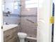 Modern bathroom with a glass shower, gray tile, grab bar and wooden vanity at 601 Gay Rd, Seffner, FL 33584