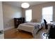 Bedroom with a comfortable bed, a dark wood bookshelf, hardwood floors, and natural light from two windows at 601 Gay Rd, Seffner, FL 33584