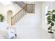 Bright foyer with tile floors, a wooden staircase with iron railings, and a white armchair at 601 Gay Rd, Seffner, FL 33584