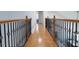 Upstairs hallway featuring hardwood flooring and detailed wrought iron banisters overlooking the living area at 601 Gay Rd, Seffner, FL 33584