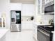 Sleek kitchen boasts stainless steel refrigerator, modern appliances, white cabinets, and updated countertops for a contemporary feel at 601 Gay Rd, Seffner, FL 33584