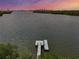 Stunning aerial view of a tranquil river and a private pier, with the city skyline gracing the horizon at sunset at 618 Wheaton Trent Pl, Tampa, FL 33619