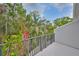Private balcony with a metal railing, offering a serene view of tropical foliage and a glimpse of blue sky at 618 Wheaton Trent Pl, Tampa, FL 33619