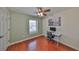 Cozy bedroom featuring hardwood floors, ceiling fan, and ample natural light from the window at 618 Wheaton Trent Pl, Tampa, FL 33619