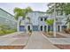 Charming townhomes boast inviting archways, blue garages, and lush landscaping, complemented by swaying palm trees at 618 Wheaton Trent Pl, Tampa, FL 33619